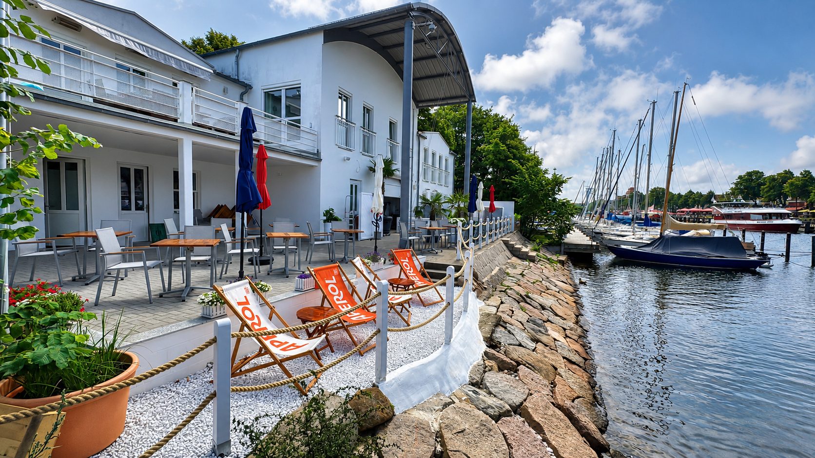 Terrasse mit Aperol-Liegestühlen am Steg